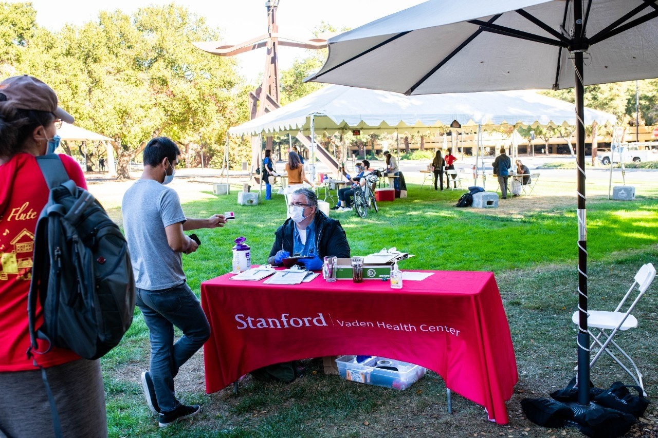 Stanford community members check in at an outdoor clinic on campus for flu shots given by the Flu Crew.